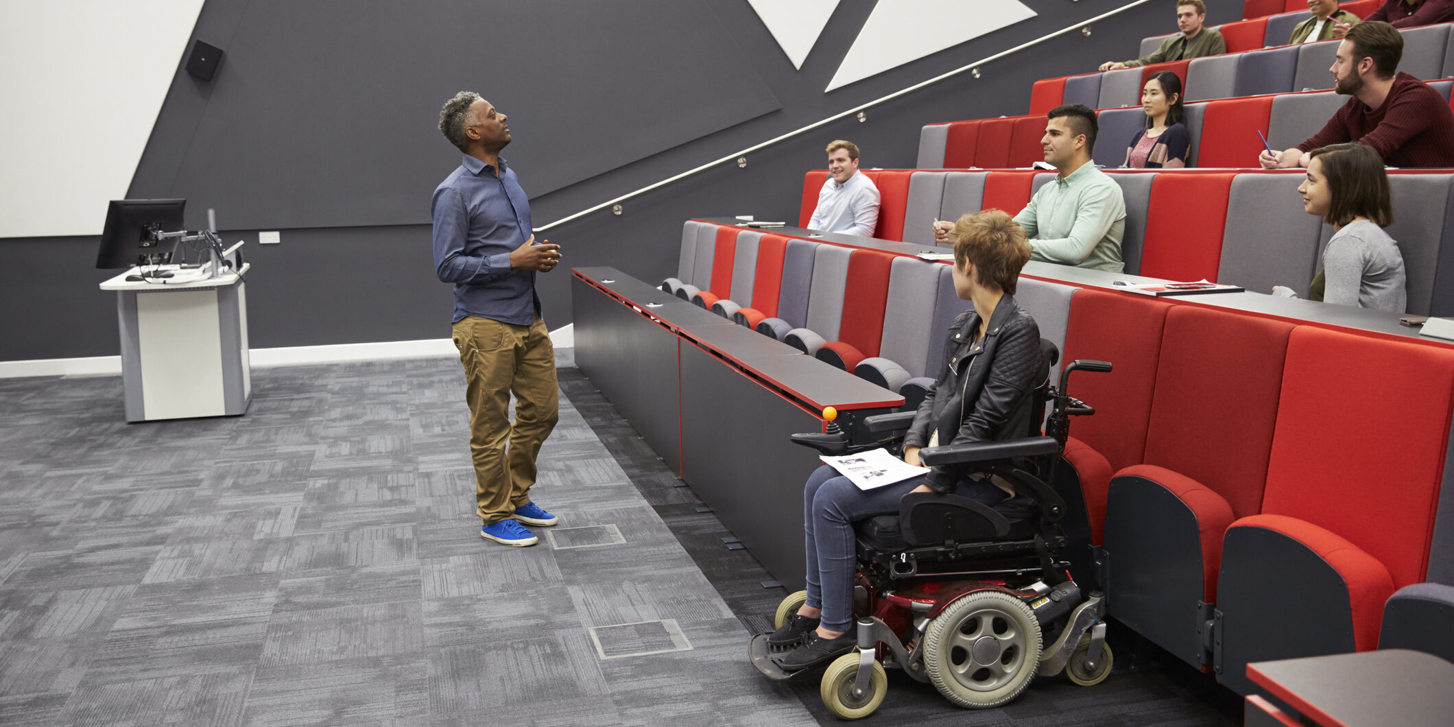 Man lecturing students in a university lecture theatre