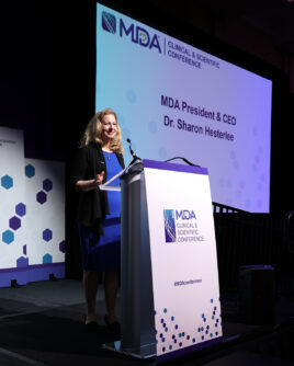 Sharon Hesterlee standing at a podium at the 2026 MDA Clinical & Scientific Conference