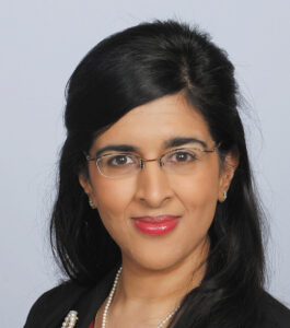 Headshot of Dr. Forum Kamdar wearing glasses and professional attire against a light gray background.