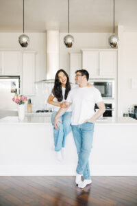 Couple smiling and embracing in a bright modern kitchen.
