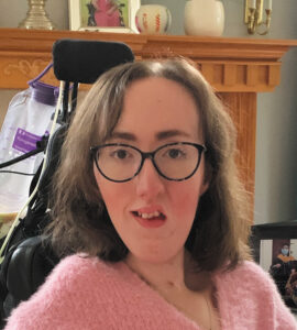 Closeup of Joanna Buoniconti wearing glasses and a pink fuzzy sweater.
