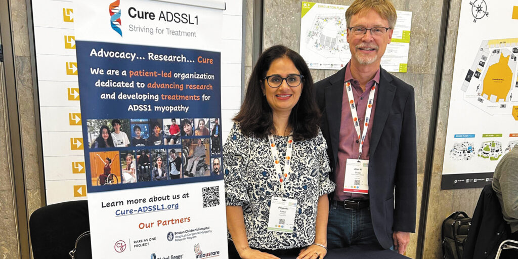 Priyanka Kakkar and Dr. Alan Beggs at a conference booth for Cure ADSSL1, an organization raising awareness and supporting research for ADSS1 myopathy.