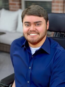Photo of Zach Fine, a young man with brown hair and a short beard