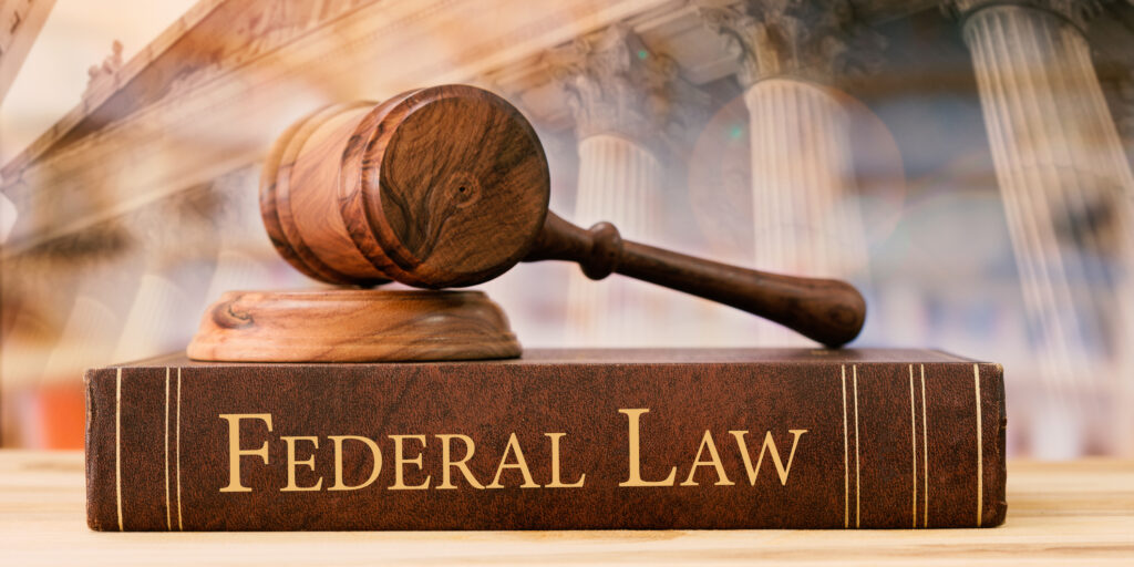 gavel judge with federal law books on desk of lawyer with court background.