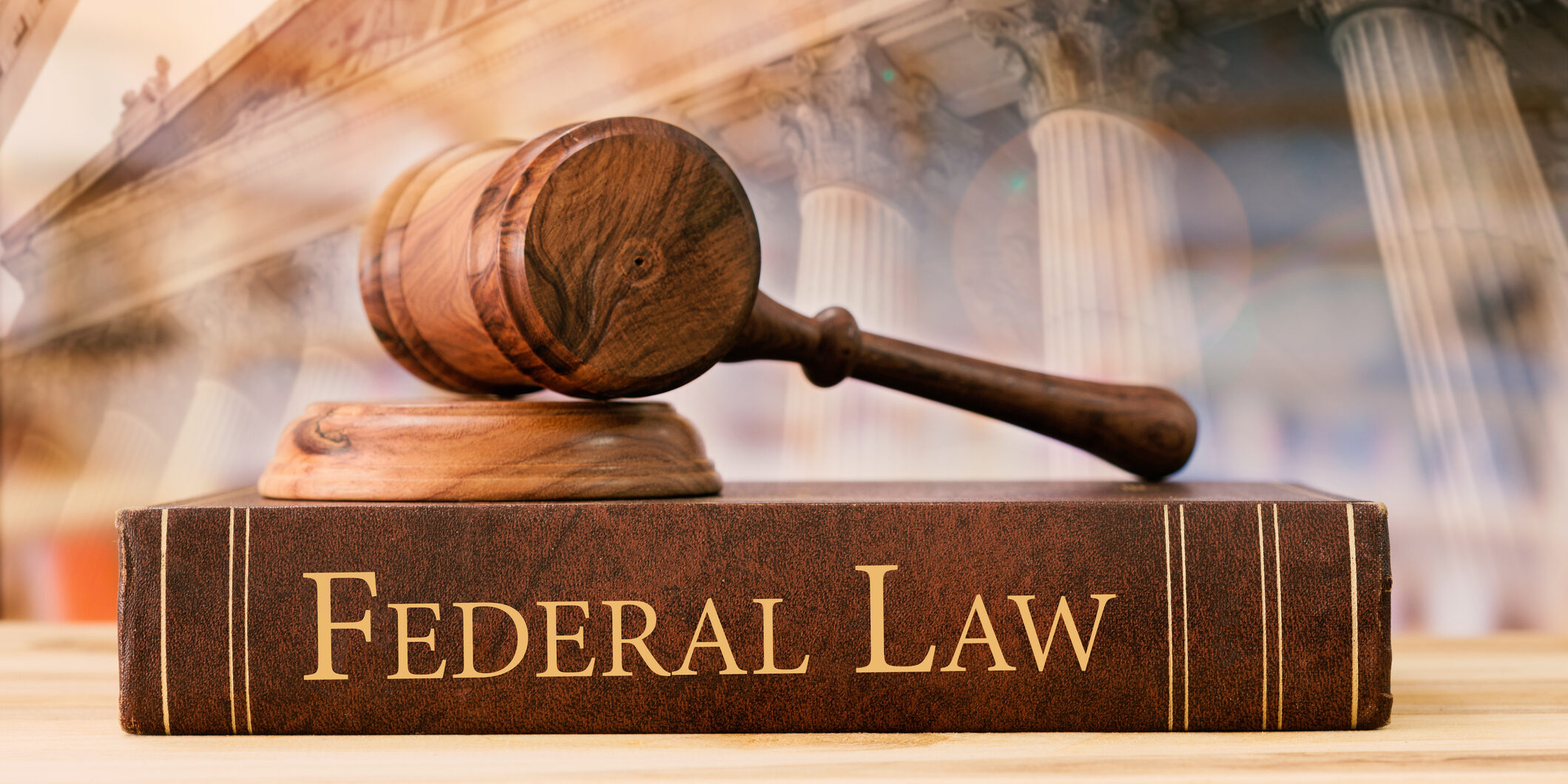 gavel judge with federal law books on desk of lawyer with court background.