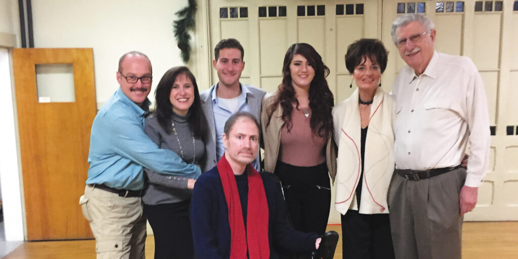 Civil rights attorney Ed Barocas, seated in a wheelchair, poses with his family indoors.