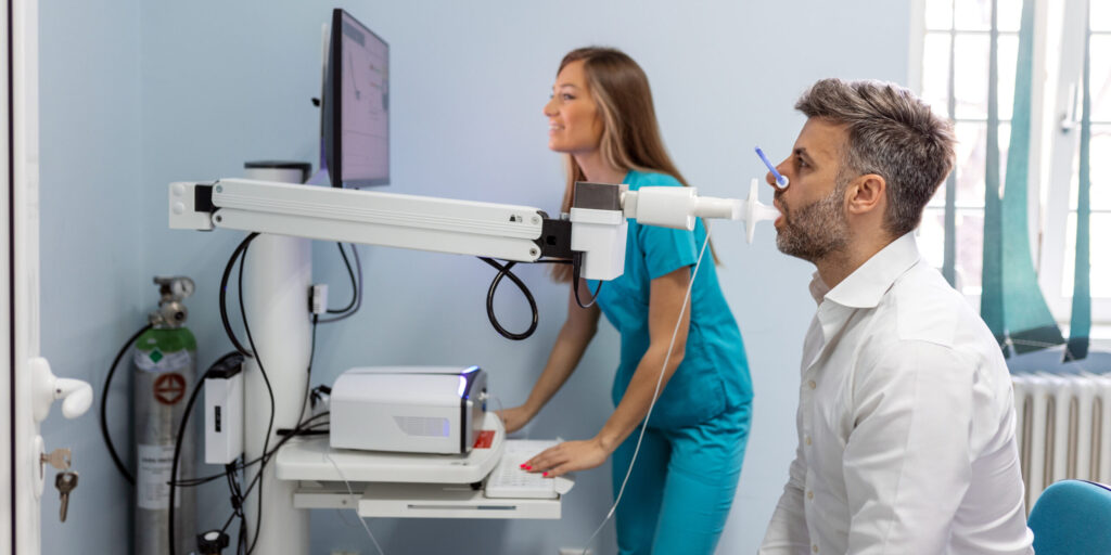 Man testing breathing function by spirometry. Diagnosis of respiratory function in pulmonary disease