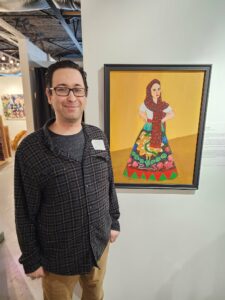 Rodrigo Duran stands with the painting "China Poblana" at the opening of the Chicano Art Exhibition