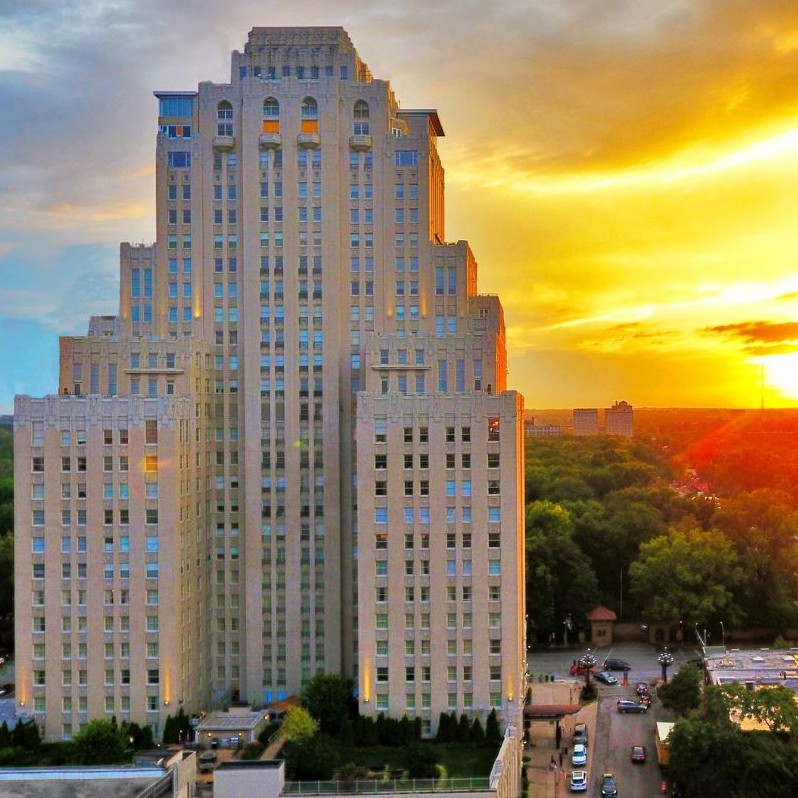 Brick and terra cotta hotel tower blending Italian Renaissance and Art Deco styles set against a brilliant sunset.