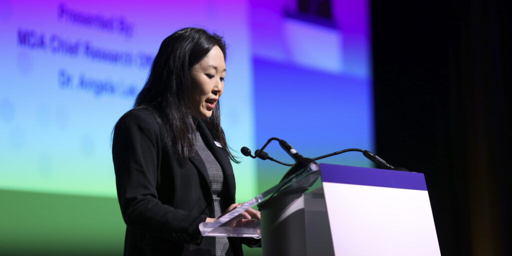 Dr. Angela Lek's speaks at a podium on stage at the 2026 MDA Clinical and Scientific Conference
